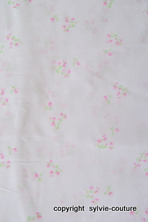 Tissu en coton blanc avec fleurs.